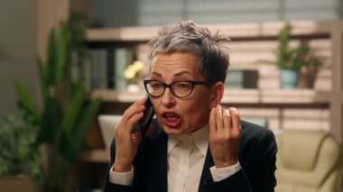 Öfkeli bağırışlar, cep telefonlu, orta yaşlı Avrupalı iş kadını, olgun, hoşnutsuz, işkadını, ofis konuşmaları, akıllı telefon anlaşmazlığı, kurumsal anlaşmazlık tartışmaları...