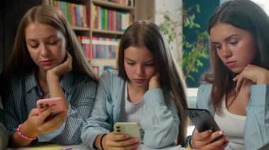 Sıkıcı bir bağımlı dört genç öğrenci sınıf arkadaşı akıllı telefon uygulamaları kullanıyor internet bağımlılığından sıkılmış gençlerin aşırı kullanımı okul kütüphanesinde cep telefonu kullanımı z genelinde sosyal medya