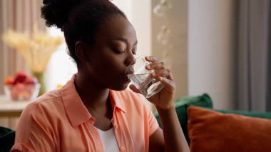 Sağlıklı gülümseyen, rahat, Afro-Amerikan iş kadını, bayan bayan, iş kadını, ev sahibi model, cam bardak, sağlık hizmeti, ev sağlığı hizmetleri, basit sağlık hizmetleri.