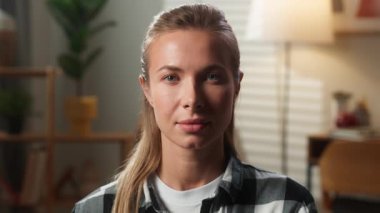 Ciddi yetişkin kadın kadın portresi. Sakin bir şekilde kameraya bakıyor. Kendine güveni tam. Ev hanımının eşinin vesikalık resmi. Kapalı kapılar ardında gülümsemeden bakıyor.