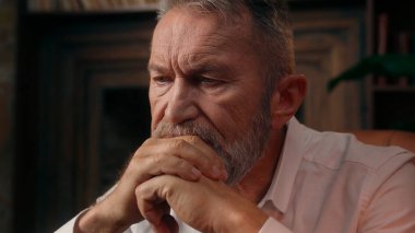Çerçevelenmiş fotoğraf fotoğraflarına bakan yaşlı beyaz adam eski anıları hatırlıyor. Emekli erkek, yaşlı, kıdemli, büyük baba sağlık hekimliği, kapalı mekan işadamı ve olgun ev gözlüğü.