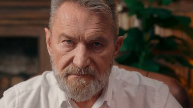 Ciddi bir şekilde Kafkas Avrupalı yaşlı adam kameraman iş adamına bakarken gözlük takıyor patron katı şef profesör olgun yaşlı sağlık bürosu çalışanı erkek doktor.