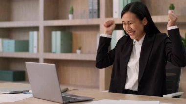 Coşkulu mutlu Çinli kadın iş kadını Çinli kız iş kadını etnik Japon iş kadını laptop bilgisayarlı bilgisayarda çalışıyor zafer kazandı kumar şaşkınlığı kapalı alanda şok etkisi yarattı