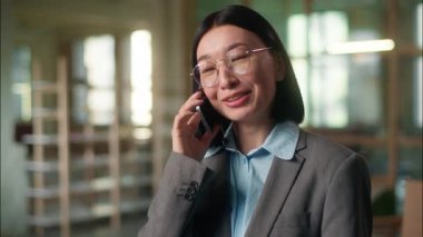 gülümseyen Asyalı iş kadını ofisteki mutlu Koreli Çinli kadın iş kadını iş kadını kadın girişimci inşaat sektöründe çalışan yönetici cep telefonu akıllı telefon bağlantı görüşmesi