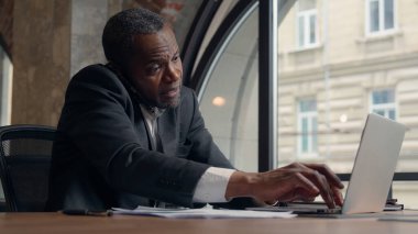 Sinirli, sinirli, sinirli, sinirli, sinirli, Afro-Amerikalı, yetişkin erkek, iş kavgası, arama kağıtları... cep telefonu işadamı, ofisteki, dizüstü bilgisayarlı, belgeli bir erkek hakkında konuşmak...