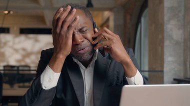 İş problemleri, Afrikalı Amerikalı yetişkin yöneticiler cep telefonu konuşmalarında hayal kırıklığına uğradılar. Kötü haber işitme, orta yaşlı erkek işçi, ofis işvereni baş ağrısı.