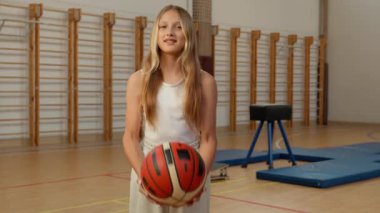 Kafkasyalı liseli kız top atan genç kız öğrenci kız öğrenci beden eğitimi oynayan sporcu kız mutlu basketbol oynayan, gülümseyen, üniversite sınıfı beden eğitimi öğrencisi