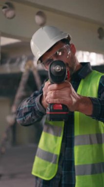 POV rotary matkap meşgul Kafkasyalı işçi tamirci tamirci tamirci tamirci tamirci tamirci tamirci tamirci tamirci tamirci tamirci malzeme endüstrisi inşaatında elektrikli alet tutan sondaj işçisi