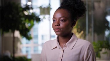 Ofis portresi Afro-Amerikalı iş kadını, etnik kız güzel kız öğrenci sakin iş kadını işveren müdürü kapalı alanda çalışan profesyonel iş adamı şirket girişimcisi kameraya bakıyor.