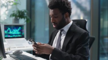 Stresli Afrikalı Amerikalı adamın cep telefonu akıllı telefon kullanması sorun yaratıyor olumsuz iş adamı şok oluyor kötü haber okuyan erkek iş adamı yöneticisinin internet ofisini kaybetmesine neden oluyor