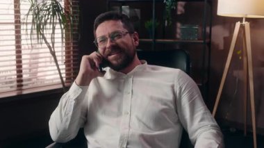 Neşeli Kafkasyalı yönetici, işveren, patron, yetişkin erkek gülüşü, cep telefonu iş görüşmesi, iş adamı, ofiste iş görüşmesi, mutlu girişimci yöneticisi, akıllı telefon görüşmeleri.