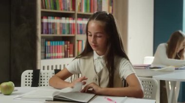 Kafkasyalı genç kız, sakin küçük kız, sınıfta okuyor, konsantre öğrenci, kitap okuyor, kütüphanede ders kitabı okuyor, liseli kız, okulda ders kitabı okuyor.