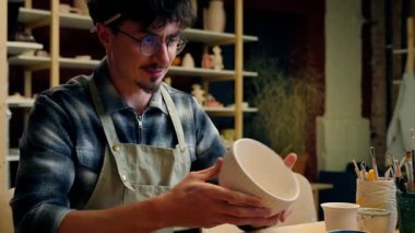 Beyaz tenli erkek çömlekçi öğretmen ressam blog yazarı usta zanaatkar dekoratör seramik tasarımcısı çanak toprak yapımı el yapımı kil modelleme atölyesi konuşma videosu görüntülü bilgisayar çevrimiçi çömlekçilik sınıfı