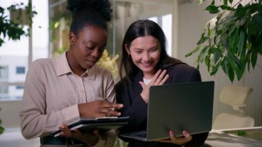Çok ırklı iş ortakları kız Afrikalı iş kadınları profesyonel takım çalışması kurumsal ofiste Çinli kadın meslektaşlar iş arkadaşları yöneticiler fikir dizüstü bilgisayarlarını ofiste tartışırlar.