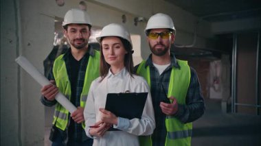 Neşeli Kafkas denetçisi kadın ustabaşı mutlu erkekler poz veriyor işçiler tamirciler inşaat işlerinde tamirciler mutlu erkek mühendisler endüstriyel makineler inşa eden işçilerin portresini yapıyor.