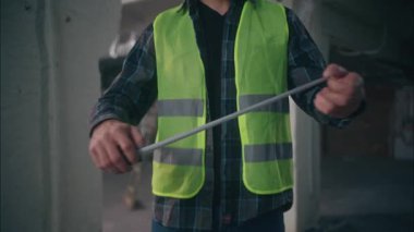 Ciddi bir Kafkas erkek müteahhit, cetvel mimarı tutuyor. İnşaatta çalışan tamirci tamirci, ölçü ruleti ile tamir eden tamirci, bant cetvelini kullanıyor.