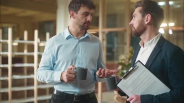 Beyaz erkekler ofiste dostça sohbet ederler kahve içerler iş arkadaşlarıyla iş arkadaşları iş arkadaşları iş arkadaşları iş arkadaşlarıyla şirket danışmanlığında buluşurlar.