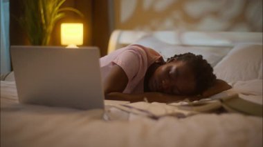 Yorgun, Afro-Amerikan, etnik kadın, bayan, kız öğrenci, uyuyan. Bilgisayarı açtı, uykusuzluk çekiyordu. Ödevler üzerinde çalışıyordu.