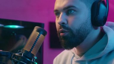 Ciddi bir yakın plan Kafkas erkek oyuncu flaması mikrofon akışı internet video oyunu internet yayını internet şampiyonluğu siber spor savaş bağımlısı ev gecesi bilgisayarı