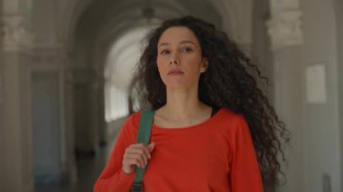 İspanyol asıllı ciddi kız öğrenci üzgün kız üniversite koridorunda yürüyor kaba agresif kız sınıf arkadaşı omuz itiyor zorbalık yapıyor problem okulunda zorbalık yapıyor