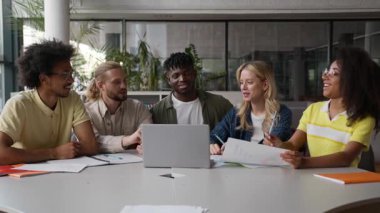 Bir grup çok ırklı öğrenci, lise öğrencileri arasında e-öğrenim görüyor. Üniversitede erkek, kız, erkek, kız, erkek, erkek, bilgisayarla gülüyor ve konuşuyorlar. Sınav konularını tartışıyorlar.