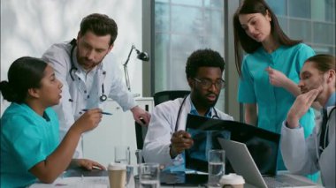 Çok kültürlü beş kişi, beyaz Hintli Afrikalı erkek kadın doktorlar teşhis koymayı tartışıyor, akciğerleri analiz ediyor, röntgen lideri hastanede stajyer doktorlara danışmanlık yapıyor.