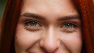 İnsan yeşil gözleri açık, kirpikleri kapalı, beyaz, güzel bir kadın açık hava, güzellik, göz, görüş, sağlık, makyaj, mutlu, gülümseyen iş kadını portresi.