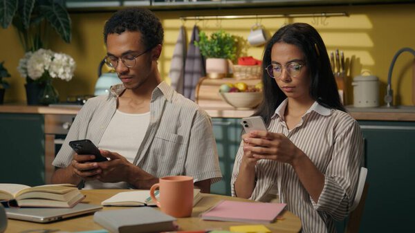 Мультирасовые подростки старшеклассники парень девушка афроамериканец мужчина арабская женщина игнорируя просмотр смартфонов онлайн покупки на домашней кухне социальных медиа наркоман с помощью гаджетов играть мобильные телефоны