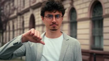 Gözlüklü 30 'lu yaşlarda, memnun olmayan bir Avrupalı adamın portresi. Kameraya bakıyor. Anlaşamadığımızı gösteriyor.