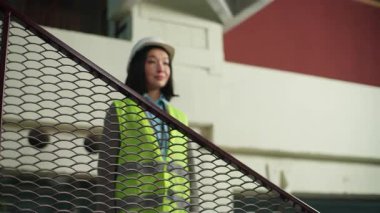 İnşaata bakan Asyalı Koreli Çinli kadın gülümseyerek el ele tutuşuyor teknik müteahhit kadın müfettiş kız müteahhit mimar fabrikada inşaat mühendisi.