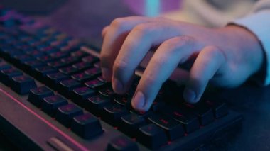 Çevrimiçi çalışan, bilgisayar klavyesini kapatan, İnternet 'te çalışan, e-öğrenen bilgisayar korsanı, tanınmayan erkek oyuncu, video oyunu web kodlaması, modern teknoloji neon ışıkları siber-bilgisayar oyunları oynayan.