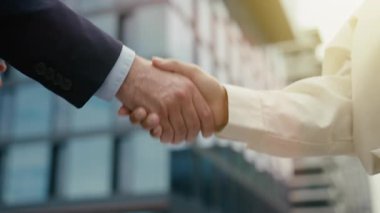 Kapalı kapılar ardında iş anlaşmasında kadın ve erkek, iş kadını ortaklığı jesti başarılı takım çalışması işbirliği ile çok ırklı erkek işadamlarıyla tokalaşıyor.