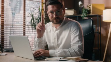 Ofiste dizüstü bilgisayarda çalışan Kafkas işçi ajan işvereni el sallıyor. El hareketi yasaklayan satış elemanı. İşaretleri reddeden erkek.