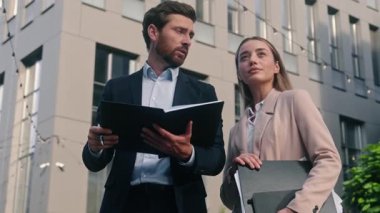 Elinde belge tutan iki iş arkadaşı, iş kadını kadın erkek, kadın, erkek takım çalışması ile iletişim kurarak şehir merkezindeki kentsel yatırım anlaşmasını tartışıyor.