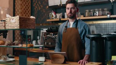 Kafeteryada çalışan mutlu beyaz adam kafeterya sahibi, silah işçisi, gülümseyen restoran çalışanı, yiyecek dükkanında çalışan, küçük işletme başarısı olan garsonluk yapan adam.