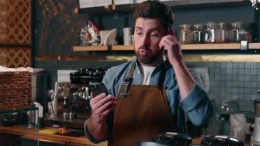 Kafeteryadaki hayal kırıklığına uğramış Kafkasyalı barista çalışanı Kafeterya 'da cep telefonu arayan kafası karışmış garson adam elinde akıllı telefon çalışanı problemi olan adam başarısız oldu kafeterya erkek iflası teknolojisi