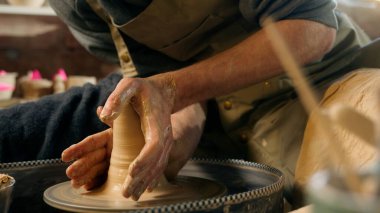 Adam yeni bir kil ürün yontuyor vazo yontuyor tencere kapları ustası erkek zanaatkar satıcı çömlekçi yaratıcısı atölye hobisi el işi el işi kil işi el işi.