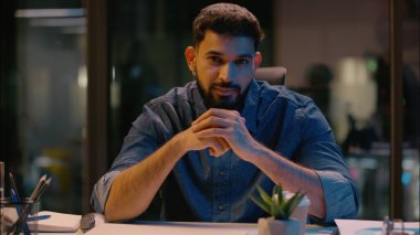 Hintli adam gülümseyen, pozitif adam, erkek iş koçu, akıl hocası, iş adamı, girişimci lideri, karanlık gece ofisindeki İnsan Kaynakları müdürü kamera danışmanlığı, motivasyon konuşması, danışmanlık, danışmanlık, danışmanlık.