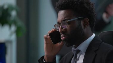 İki çok ırklı iş arkadaşı Afrika kökenli Amerikalı beyaz iş adamı erkekler yöneticiler iş adamları iş arkadaşları cep telefonuyla konuşan akıllı telefon görüşmeleri danışman müvekkil destek çalışanları