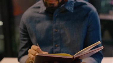 Hintli iş adamı notlar yazıyor düşünceli etnik iş adamı gece ofisindeki erkek girişimci fikir planlama gece geç saatlere kadar çalışıp ders kitabını analiz etmeyi düşünüyor.