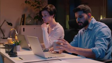 Kafkasyalı iş kadını laptoplarda çalışan çok ırklı iş kadını Kafkasyalı iş kadını kahve içip fazla mesai yapan iş adamı bilgisayarları programlıyor bilişim şirketi yöneticileri kız iş arkadaşları online ticaret yapıyor.