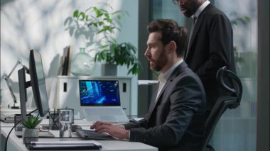 Belge tutan Afrikalı Amerikalı yönetici Kafkasyalı iş arkadaşına geldi. Çok ırklı iş adamlarına. Bilgisayarları kontrol eden iş adamları.