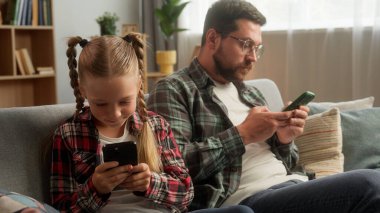 Kafkasyalı internet bağımlısı erkek baba çocuk aile cep telefonu akıllı telefon bağımlılığı kullanıyor küçük kız çocuk baba dijital oyun oynuyor aile teknolojisi uygulaması