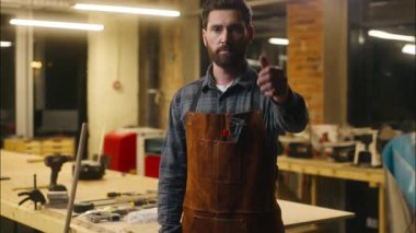 Gülümseyen Kafkas ahşap ustası marangoz atölyede baş parmağını gösteriyor katılan adam işaret sanatçısı erkek destek tamircisi olumlu tabela tamircisi marangozluk iyi iş jesti