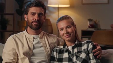 Kafkasyalı yetişkin çift evli koca evli kadın ev sahipleri gülümseyen kız arkadaş kameraya bakıyor sevgi kucaklaşması geceleri ev kredisi kredisi kredisi