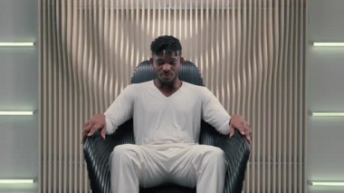 Fütürizm, Afro-Amerikalı etnik bir adamın jest gibi ortaya çıkması kabul edilebilir beyaz fütüristik odadaki erkek erkeğin kapalı bir yerde, siber punk siber-uzay tarzı modern teknoloji koltuğunda oturmasını önerir.