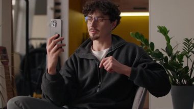Gülümseyen Kafkasyalı blogcu konuşma cep telefonu evde hipster video blogu kaydediliyor erkek müzakere web konferansı çağrı adam internetteki bloglarda vlog uzak teknoloji akışı sosyal medya