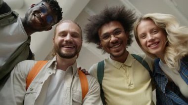 Alttaki grup çeşitli üniversite arkadaşları gülümseyen dört çok ırklı öğrenci üniversite salonundaki beyaz kadın Afrikalı Amerikalı erkekler çok kültürlü arkadaşlıklar.