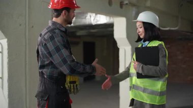 İki Kafkasyalı Japon müteahhit erkek müteahhit kadın sanayi işçisi mühendis ekip işbirliği el sıkışma jest anlaşması iş ortaklığı inşaat sahası