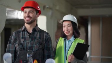 İki Kafkasyalı Japon müteahhit erkek işçi kadın sanayi işçisi. Kağıtları inceliyorlar. İnşaat işleri müfettişi başarı teftişini kutluyor.